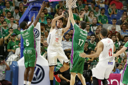 Huskic dobla un balón ante la presión de los jugadores del Unicaja Soluade y Shermadini.-ACB PHOTO / M. POZO