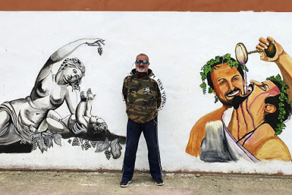 El alcalde de Baños frente a uno de los murales en el pueblo. L. V.