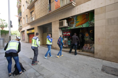 Agentes de la Policía Nacional entran en la sede de la Fundació CATmón.-/ RICARD FADRIQUE
