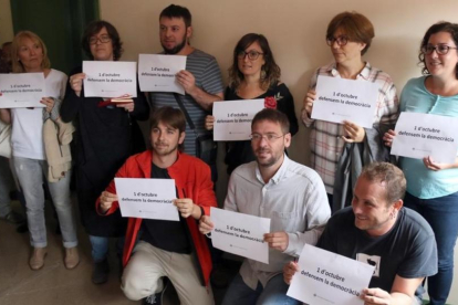 Diputados de la CUP y de Podem en Barberà del Vallès con carteles a favor de la democracia y del referéndum.-LAURA CORTÉS