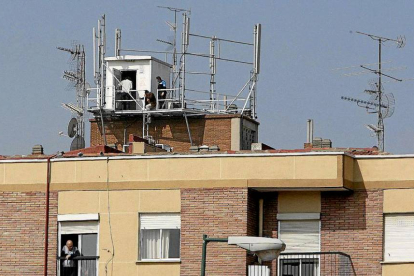Dos técnicos revisan la instalación de las antenas de un edificio.-LOSTAU