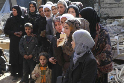 Mujeres de Yarmuk esperan la entrega de ayuda humanitaria.-Foto: HANDOUT / REUTERS