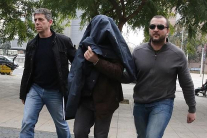 Joaquim Benítez entra en la Ciutat de la Justícia de BCN custodiado por dos mossos.-