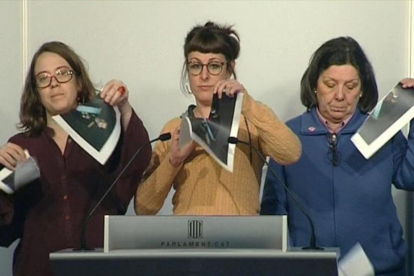 Las diputadas de la CUP Eulàlia Reguant, Mireia Vehí y Gabriela Serra rompen fotos del Rey en una rueda de prensa en el Parlament, el pasado día 12 de diciembre.-EFE