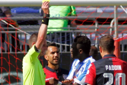 El árbitro Daniele Minelli saca la tarjeta amarilla a Muntari durante el Cagliari-Pescara del domingo.-FABIO MURRU