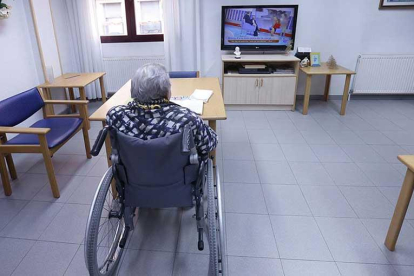 Una persona mayor en situación de dependencia ve la televisión en una residencia de la Diputación.-RAÚL G. OCHOA