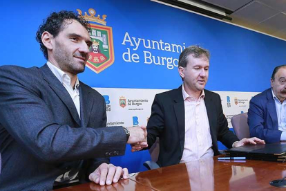 Jorge Garbajosa y Javier Lacalle se estrechan lamano tras firmar el acuierdo en presencia de Carlos Sainz.-RAÚL G. OCHOA