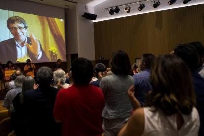 Carles Puigdemont saluda, a través de una pantalla, a los asistentes a la presentación de Crida Nacional per la República-EFE / QUIQUE GARCÍA