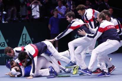 El equipo francés se abalanza sobre Lucas Pouille tras conseguir el punto definitivo sobre Steve Darcis en la final de la Copa Davis.-AP / CHRISTOPHE ENA