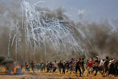 Los palestinos huyen de los gases lanzados por soldados israelís en Gaza.-AFP / MOHAMMED ABED