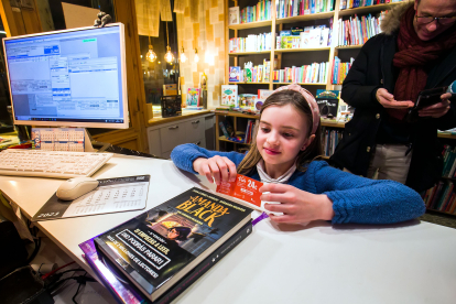 Una niña canjea un bono de lectura en una librería. TOMÁS ALONSO