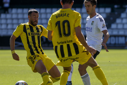 Aitor Córdoba disputa un balón entre dos jugadores del Real Oviedo en el partido de la quinta jornada en El Plantío. S. OTERO