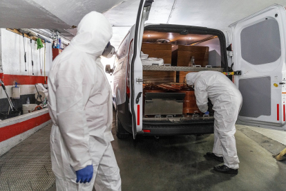Dos trabajadores de la funeraria Santa Teresa de Segovia, en una imagen de archivo en plena primera ola de la pandemia durante el mes de abril.  ICAL