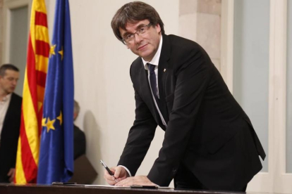 El president Carles Puigdemont en el momento de firmar la declaración, tras el pleno-JULIO CARBÓ