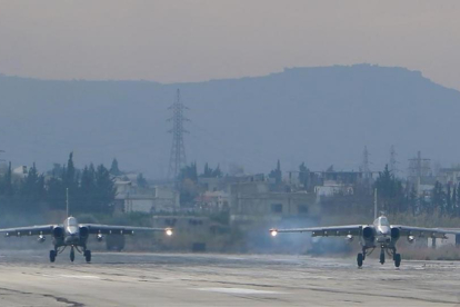 Dos aviones de combate Sukoi Su-25 rusos, en diciembre del 2015, despegando en la base militar de Hmeimim, en el noroeste de Siria.-AFP / PAUL GYPTEAU