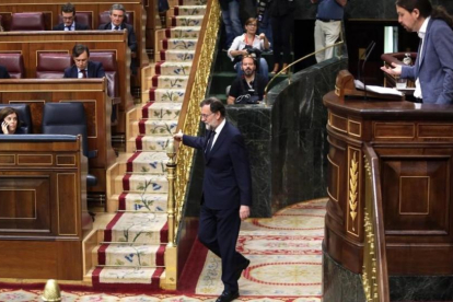 Mariano Rajoy vuelve a su escaño durante la intervención de Pablo Iglesias en la moción de censura.-JUAN MANUEL PRATS