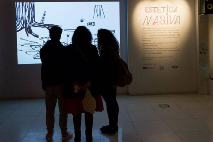 Tres visitantes ven el vídeo de David Shrigley.-Mendía Echeverría.