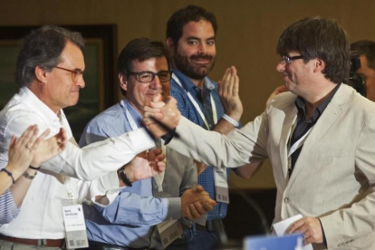 El presidente de la Generalitat, Carles Puigdemont (derecha) saluda al 'expresident' Artur Mas en el acto de Lloret de Mar.-Robin Townsend