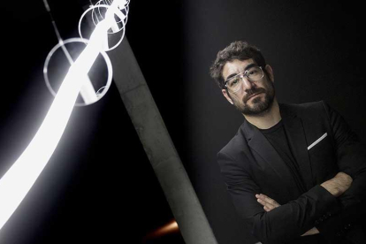 Solimán López posa al lado de la pieza de luz que materializa la estela dejada por un globo sonda lanzado al espacio hasta que se perdió su pista.-SANTI OTERO