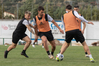 Claudio conduce el balón ante la presión de Juanma en un entrenamiento durante la concentración en Extremadura. BURGOS CF