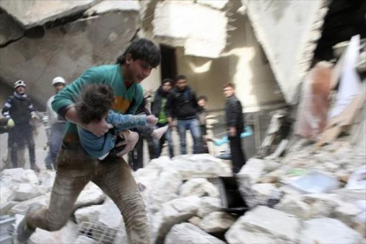 Un hombre traslada a una niña herida tras un bombardeo en Alepo.-REUTERS / Karam al Halabi