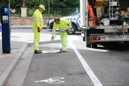 Los operarios pintan las marcas viales del aparcamiento para motos de la calle Condestable. SANTI OTERO