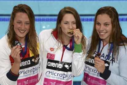 Mireia Belmonte (izquierda, plata) y María Vilas (derecha, bonce) flanquean a la húngara Boglarka Kapas tras recibir sus respectivas medallas en la prueba de los 1.500 metros libre en los Campeonatos de Europa de Natación de Londres.-REUTERS / TONY O'BRIEN