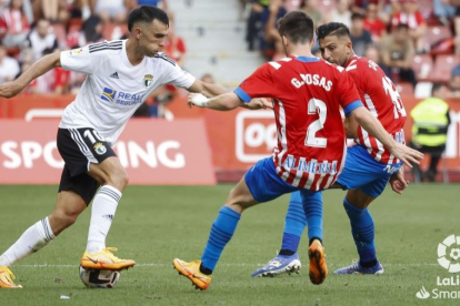 Bermejo conduce el balón ante la presión de los defensores del Sporting de Gijón. LALIGA