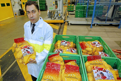 Javier Meléndez, con una de las bolsas de cinco kilos recién salida de la línea de produccion de la  fábrica de Patatas Meléndez en Medina del Campo.-J. M. LOSTAU