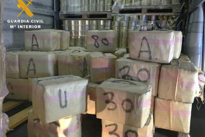 Paquetes de droga escondidos entre el cargamento de latas de conserva.-ECB
