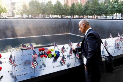 Un hombre acaricia los nombres grabados de los bomberos fallecidos en la parte sur del recordatorio a las víctimas del 11 de septiembre durante la ceremonia del 18º aniversario de la masacre.-JUSTIN LANE (EFE)