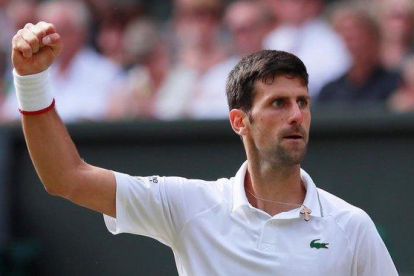 Djokovic celebra un punto ante Federer en la final de Wimbledon.-