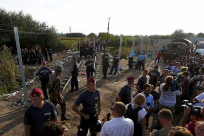 Policías húngaros forman una barrera humana para cortar el flujo de refugiados desde Serbia.-REUTERS/LASZLO BALOGH