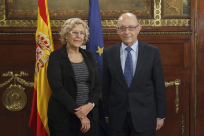 La alcaldesa de Madrid Manuela Carmena y el ministro de Hacienda Cristóbal Montoro.-EFE