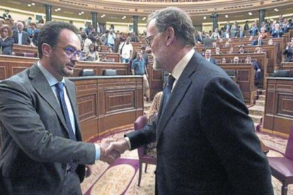 Mariano Rajoy y el socialista Antonio Hernando se dan la mano tras la segunda votación del pleno de investidura.-POOL