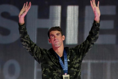 Phelps saluda desde el podio tras conquistar el triunfo en los 100 mariposa-TOM PENNINGTON / AFP