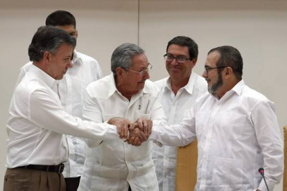 Raúl Castro sostiene las manos estrechadas del presidente de Colombia, Juan Manuel Santos, y del líder de las FARC, Rodrigo Londoño, alias 'Timochenko', este miércoles en La Habana.-EFE / ORLANDO BARRIA