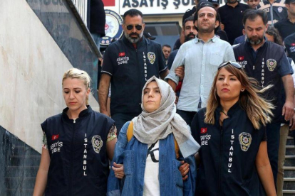 La policía escolta a una periodista detenida ante el juez en Estambul.-ALI AKSOYER