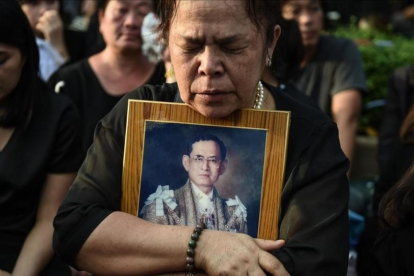 Una mujer llora la muerte del rey Bhumibol de Tailandia frente al Gran Palacio de Bangkok.-AFP / LILLIAN SUWANRUMPHA