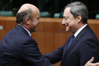 El ministro de Economía, Luis de Guindos, y el presidente del BCE, Mario Draghi, en una imagen de archivo.-FRANCOIS LENOIR / REUTERS