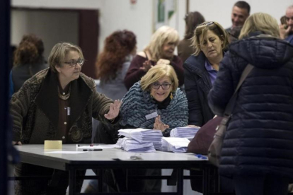 Miembros de una mesa electoral abren los sacos con las papeletas del referéndum.-EFE / MASSIMO PERCOSSI