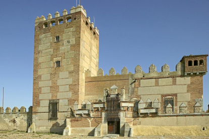 Sorprendente silueta del castillo de Narros de Saldueña, de planta cuadrada y con una gran torre del homenaje.-
