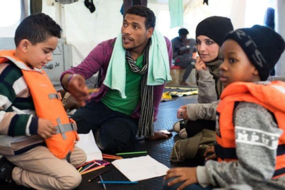 Fotografia cedida por la ONG Sea-Watch que muestra a Nasreen  2d  y a su hijo Zizou  i  junto a otros inmigrantes a bordo del buque Sea Watch 3 en el mediterraneo el 23 de diciembre de 2018.-SEA WATCH