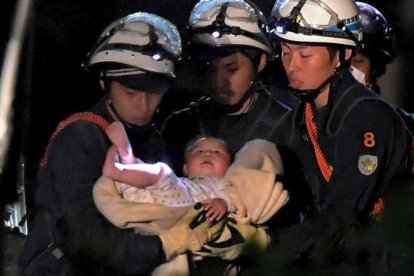 Un bebé de ocho meses rescatado por los trabajadores de emergencias el viernes en Japón.-REUTERS / DAISUKE WADA