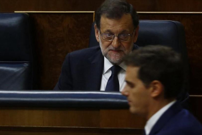 El presidente del Gobierno, Mariano Rajoy, en una sesión parlamentaria observa el paso del líder de Cs, Albert Rivera.-AGUSTÍN CATALÁN
