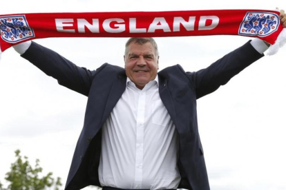 Sam Allardyce extiende una bufanda para los fotógrafos, este lunes en el St.George's Park de Burton Upon Trent.-REUTERS / ANDREW COULDRIDGE