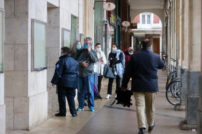 Varias personas haciendo cola a la puerta del Ayuntamiento de Burgos. ECB