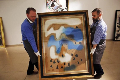 Dos operarios portugueses trasladan en febrero del 2014 una obra de Miró para la subasta que finalmente no se llevó a cabo.-AP