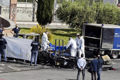 La policía forense cubre un cadáver sacado de la caravana donde murieron tres hermanas gitanas, en Roma, el 10 de mayo.-AP / MASSIMO PERCOSSI