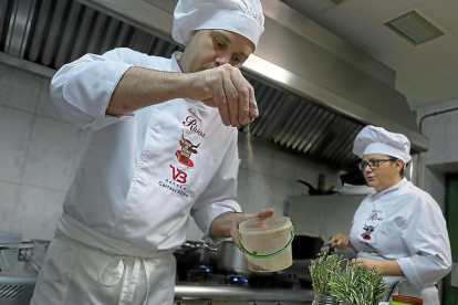 Óscar Barreno y la jefa de cocina Ana Rosa Cuadrado mientras trabajan en la cocina del Rivas (Salamanca).-ENRIQUE CARRASCAL